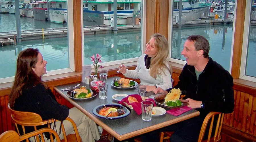 Ray’s Waterfront offers stunning views of mountains, marine life, and the bustling boat harbor in Seward